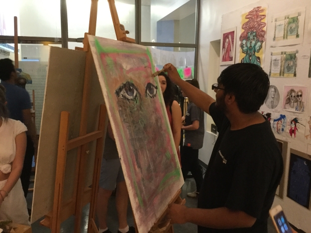 Art senior, Tashfeen Ali, does a live painting at the recent senior art show. Tashfeen will be going to an arts-based college in the Fall.